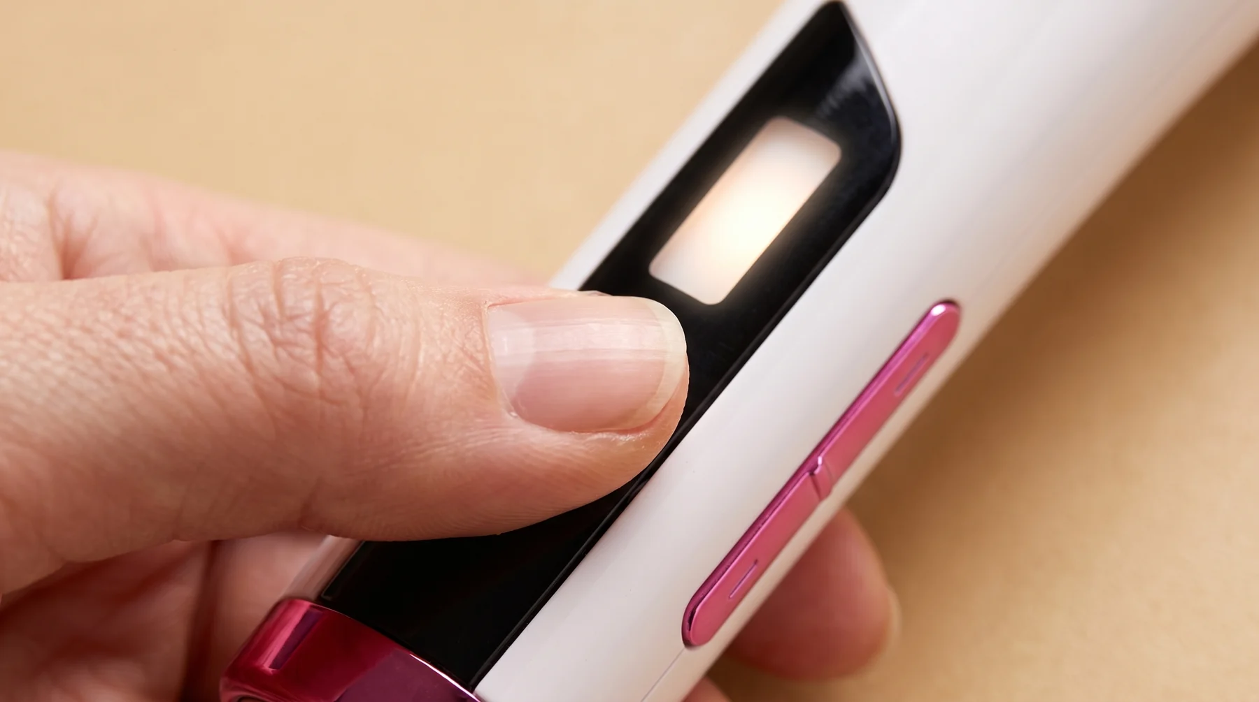 Pouce appuyant sur le bouton d'alimentation de la poignée Dualsonic Optimum, écran d'état allumé